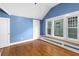 A bright bedroom with hardwood floors, blue walls, and a set of white framed windows at 966 Blue Ridge Ne Ave, Atlanta, GA 30306