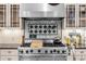 Close up of kitchen stove, tiled backsplash, and custom cabinets with lighting at 966 Blue Ridge Ne Ave, Atlanta, GA 30306