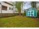 A cozy backyard featuring a well-maintained lawn and a charming teal shed at 1027 Kirkwood Se Ave, Atlanta, GA 30316