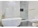 Bright bathroom featuring a soaking tub, stylish lighting, and a glass-enclosed shower at 1456 S Gordon Sw St, Atlanta, GA 30310