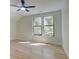 Bedroom with light-colored walls, hardwood floors, a ceiling fan, and a double window view of surrounding trees at 1456 S Gordon Sw St, Atlanta, GA 30310