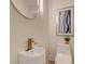 Chic powder room with a modern sink, gold faucet, round mirror and stylish lighting at 1456 S Gordon Sw St, Atlanta, GA 30310