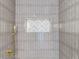 Walk-in shower with sleek vertical tiles, a built-in shelf, and gold shower hardware at 1456 S Gordon Sw St, Atlanta, GA 30310