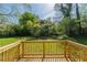 A wooden deck overlooking a large backyard with mature trees and green grass at 2877 Kensington Way, Rex, GA 30273