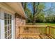 Wooden deck adjoins brick home with mature trees and green lawn in backyard at 2877 Kensington Way, Rex, GA 30273
