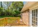 A wooden deck adjoins brick home with mature trees and green lawn in backyard at 2877 Kensington Way, Rex, GA 30273