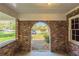 Brick archway detail of the carport, with a view of the street and front yard beyond at 2877 Kensington Way, Rex, GA 30273