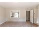 Bright living room featuring neutral carpet, paint, and a large window at 2877 Kensington Way, Rex, GA 30273