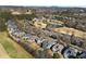 Scenic aerial view of a golf course community with lush greenery, a pond, and a row of upscale homes at 5325 Davenport Mnr, Cumming, GA 30041