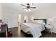 Bedroom featuring a comfortable bed, ceiling fan, and dual closets for storage at 5325 Davenport Mnr, Cumming, GA 30041