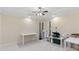 A light-filled bedroom with a ceiling fan and ample space for creative pursuits at 5325 Davenport Mnr, Cumming, GA 30041