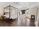 A spacious bedroom with a four-poster bed, hardwood floors, sitting area, and ample natural light at 5325 Davenport Mnr, Cumming, GA 30041