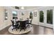 A bright dining room with dark wood floors, a round table, and chairs with views of the outside at 5325 Davenport Mnr, Cumming, GA 30041
