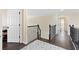 Hallway with hardwood floors, wrought iron railing, neutral walls, and white trim at 5325 Davenport Mnr, Cumming, GA 30041