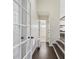 Hallway with hardwood floors, an adjacent bathroom, and stairs leading to the upper level at 5325 Davenport Mnr, Cumming, GA 30041