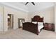 Spacious main bedroom boasts a decorative wood bed frame, tray ceiling, and neutral carpeting at 5325 Davenport Mnr, Cumming, GA 30041