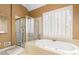 Bright bathroom features a tile-surround soaking tub and a glass-enclosed shower at 5325 Davenport Mnr, Cumming, GA 30041