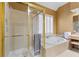 Bright bathroom features a tile-surround soaking tub and a glass-enclosed shower at 5325 Davenport Mnr, Cumming, GA 30041