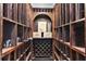 A wine cellar with custom wood racking, arched alcoves, and display shelves at 5325 Davenport Mnr, Cumming, GA 30041