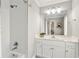 Bright bathroom features a large framed mirror, double vanity, and tiled shower/tub at 1004 Windermere Xing, Cumming, GA 30041