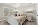 Comfortable bedroom features a ceiling fan, large windows, and neutral decor with a gorgeous carved wooden bed at 1004 Windermere Xing, Cumming, GA 30041