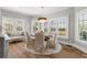 Cozy breakfast nook with round table and views of the landscaped backyard through large windows at 1004 Windermere Xing, Cumming, GA 30041