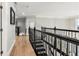 Hallway features hardwood floors, a modern metal railing, and neutral wall paint creating a bright and open space at 1004 Windermere Xing, Cumming, GA 30041