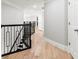 Hallway boasts hardwood floors and white walls for a clean and bright aesthetic leading to various rooms at 1004 Windermere Xing, Cumming, GA 30041