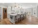 Bright kitchen features a large marble island with seating, stainless steel appliances and modern pendant lighting at 1004 Windermere Xing, Cumming, GA 30041