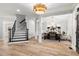 Open-concept living space featuring hardwood floors, a staircase, and designer finishes at 1004 Windermere Xing, Cumming, GA 30041