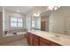 Bathroom with double sink vanity, large mirror, soaking tub, and bright window with plantation shutters at 625 Aunt Lucy Ln # 45, Smyrna, GA 30082