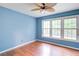 This bedroom offers hardwood floors, a fan, and a wall of windows offering lots of natural light at 1315 Bustling Sw Ln, Marietta, GA 30064