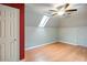 Bedroom with vaulted ceilings, skylight, fan, hardwood floors, and neutral walls at 1315 Bustling Sw Ln, Marietta, GA 30064
