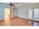 Sunlit bedroom with wood floors, a ceiling fan, and french doors with view to bathroom at 1315 Bustling Sw Ln, Marietta, GA 30064