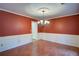 Classic dining room with wainscoting detail, laminate flooring, and a chandelier at 1315 Bustling Sw Ln, Marietta, GA 30064