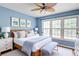 Inviting bedroom featuring a large window, ceiling fan, and a comfortable bed with stylish bedding at 1315 Bustling Sw Ln, Marietta, GA 30064