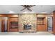 Spacious living room featuring a stone fireplace, wood paneling, and built-in shelves at 1470 Biltmore Ne Dr, Atlanta, GA 30329