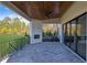 Covered patio with stone floor, outdoor fireplace, and sliding glass doors at 2875 Caney Parc Way, Cumming, GA 30041
