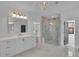 Bright bathroom showcasing a double vanity, walk-in shower, and contemporary lighting fixtures at 2875 Caney Parc Way, Cumming, GA 30041