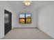 Bright bedroom features a large window, neutral carpet, and a modern light fixture at 2875 Caney Parc Way, Cumming, GA 30041