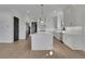 The open kitchen is equipped with a large center island, stainless steel appliances, and white cabinetry at 2875 Caney Parc Way, Cumming, GA 30041