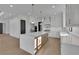 The open kitchen features a large island, stainless appliances, and stylish pendant lighting at 2875 Caney Parc Way, Cumming, GA 30041