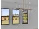 Spacious living room with a modern chandelier and multiple windows showcasing the outdoor view at 2875 Caney Parc Way, Cumming, GA 30041