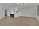 Open living space featuring an island kitchen with sleek pendant lights and hardwood floors at 2875 Caney Parc Way, Cumming, GA 30041