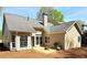 View of the backyard with a small patio, grill, and several windows overlooking the backyard at 2910 Treehouse Ln, Lawrenceville, GA 30044
