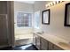 Bright main bathroom featuring double sinks, soaking tub, and large window at 2910 Treehouse Ln, Lawrenceville, GA 30044