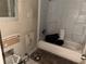 Damaged bathroom features a shower-tub combo, missing wall, and dated finishes at 6127 Pinegrove Rd, Riverdale, GA 30274