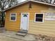 This charming home features a quaint side entrance with a white door and a view of the yard at 6127 Pinegrove Rd, Riverdale, GA 30274