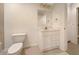 This is a white bathroom with a toilet, vanity, mirror, and a cream colored tile floor at 2123 Tigger Ne Trce, Marietta, GA 30066