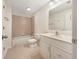 A clean bathroom featuring neutral tile, toilet, white vanity, tub-shower combo, and bright vanity lighting at 2123 Tigger Ne Trce, Marietta, GA 30066